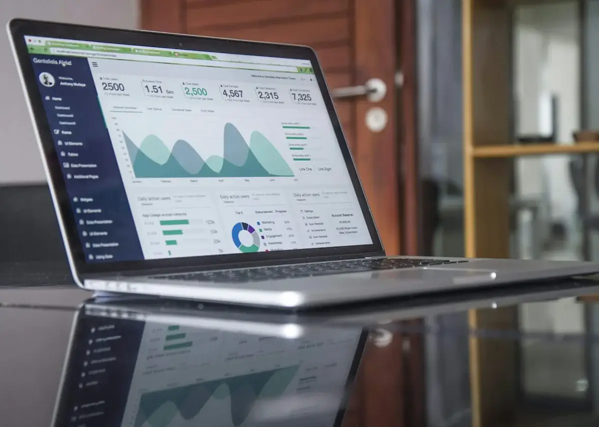Laptop showing website analytics on a glass table